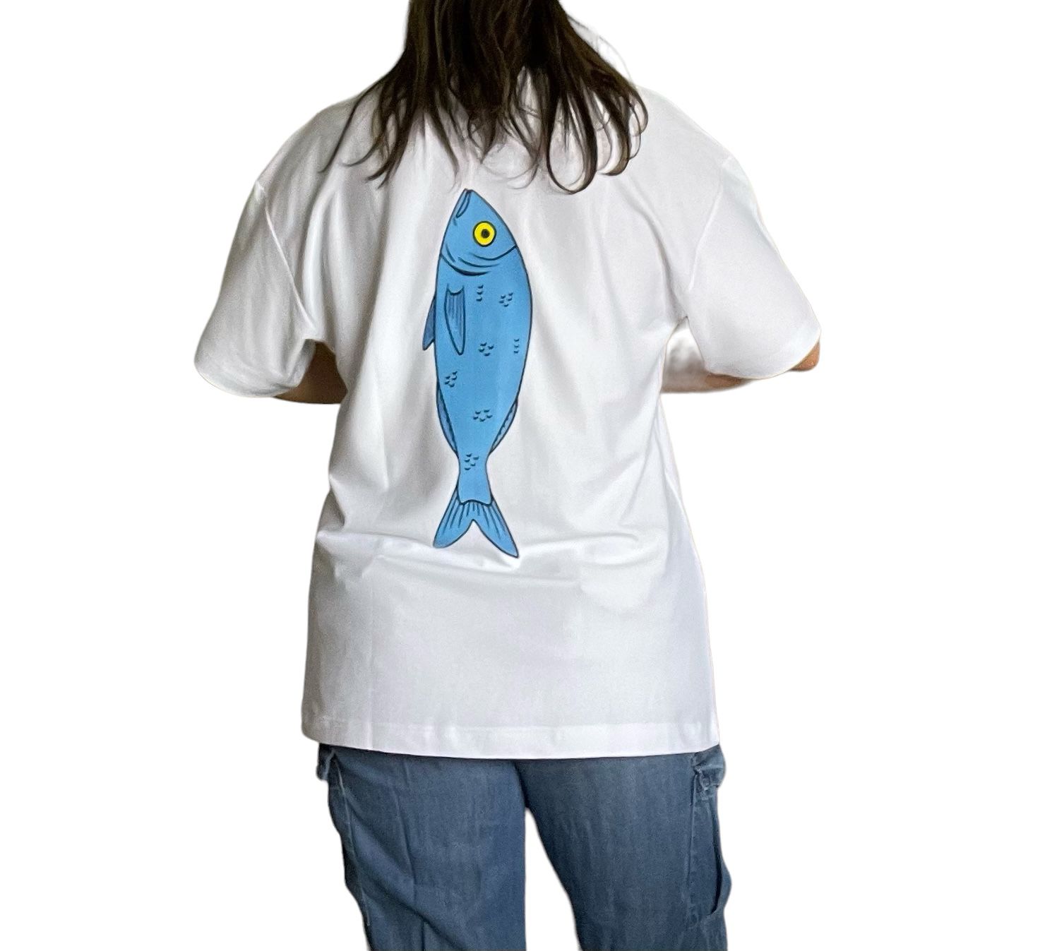 Camiseta unisex oversized de color blanco, confeccionada en 100% algodón Pima. Presenta un gran gráfico de pez azul con ojo amarillo en la parte trasera. Tela suave y transpirable con ajuste holgado para mayor comodidad y estilo.
White oversized unisex t-shirt made from 100% Pima cotton, featuring a large blue fish graphic with a yellow eye printed on the back. Soft, breathable fabric with a relaxed fit for maximum comfort and style.